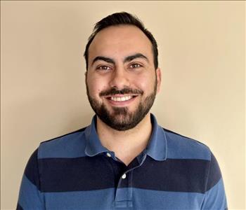 Employee smiling in striped polo